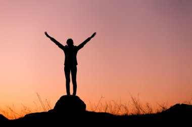 Güzel renkli gökyüzü karşı mutlu genç kadın silüeti. 
