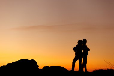 Anne ve kızının güzel günbatımında siluetleri. Dusk