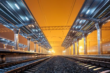 Tren istasyonunda gece. Sisin içinde tren platformu. Demiryolu