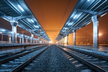 Tren istasyonunda gece. Sisin içinde tren platformu. Demiryolu