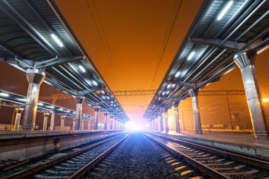 Tren istasyonunda gece. Sisin içinde tren platformu. Demiryolu