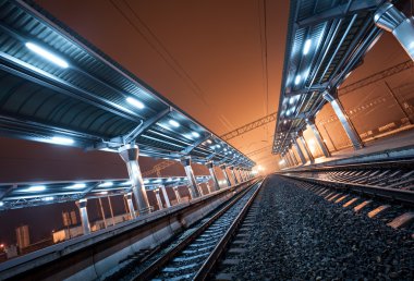 Tren istasyonunda gece. Sisin içinde tren platformu. Demiryolu