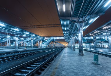 Tren istasyonunda gece. Sisin içinde tren platformu. Demiryolu