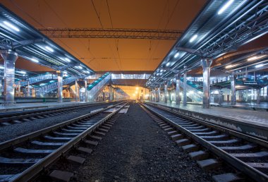 Tren istasyonunda gece. Sisin içinde tren platformu. Demiryolu