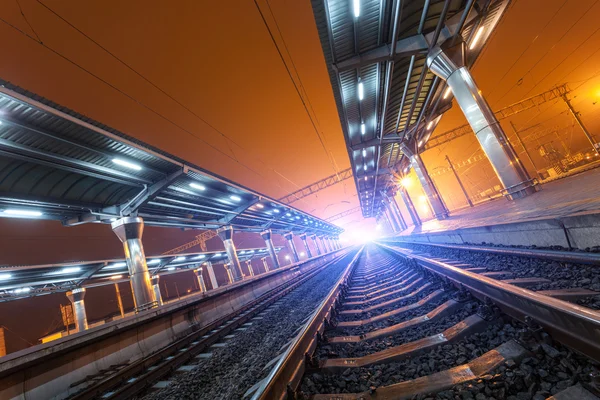 Tren istasyonunda gece. Sisin içinde tren platformu. Demiryolu