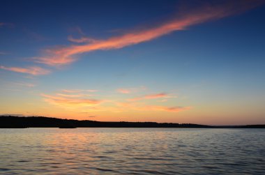Gün batımında büyük göl kenarında küçük ahşap iskele
