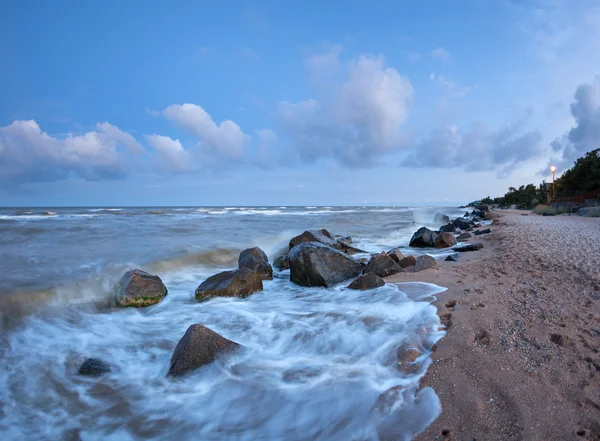 Vacker sommar solnedgång vid havet med stenar — Stockfoto