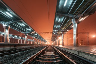 Tren istasyonunda gece. Sisin içinde tren platformu. Demiryolu