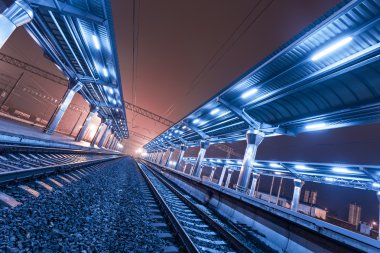 Tren istasyonunda gece. Sisin içinde tren platformu. Demiryolu