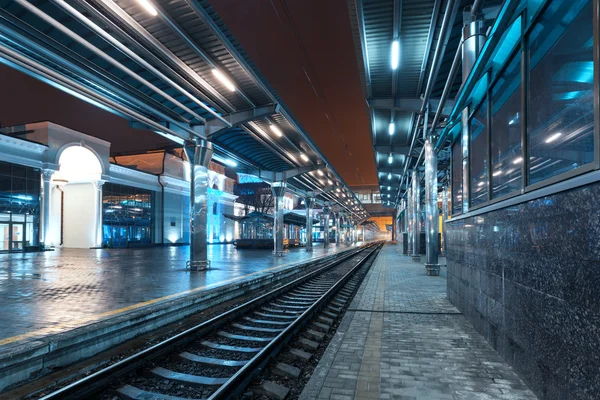 Tren istasyonunda gece. Sisin içinde tren platformu. Demiryolu