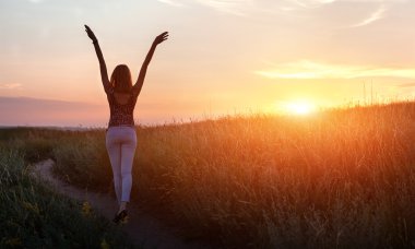 Özgür mutlu kadın silah günbatımında alanına yükselterek.