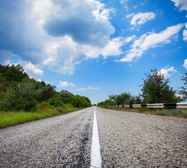 Yaz ormanında gün batımında asfalt yolda. Kırım Dağları