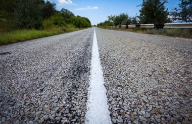 Yaz ormanında gün batımında asfalt yolda. Kırım Dağları