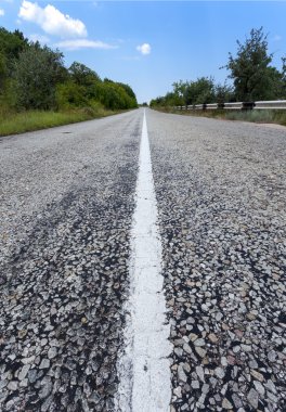 Yaz ormanında gün batımında asfalt yolda. Kırım Dağları