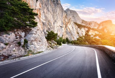 Yaz ormanında gün batımında asfalt yolda. Kırım Dağları 