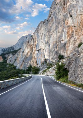 Yaz ormanında gün batımında asfalt yolda. Kırım Dağları