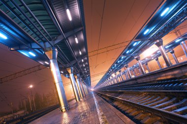 Tren istasyonunda gece. Sisin içinde tren platformu. Demiryolu