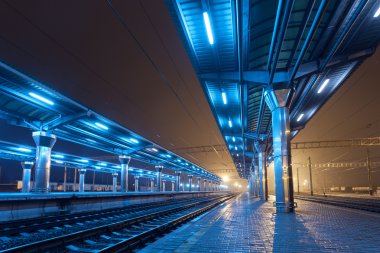 Tren istasyonunda gece. Sisin içinde tren platformu. Demiryolu