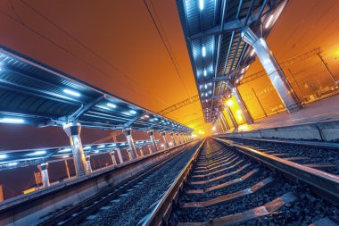 Tren istasyonunda gece. Sisin içinde tren platformu. Demiryolu