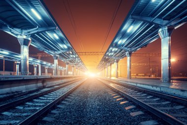 Tren istasyonunda gece. Sisin içinde tren platformu. Demiryolu