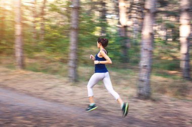 Sonbahar ormandaki kırsal bir yolda çalışan genç kadın