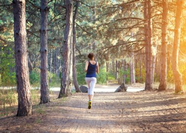 Ormanda kırsal bir yolda koşan genç bir kadın