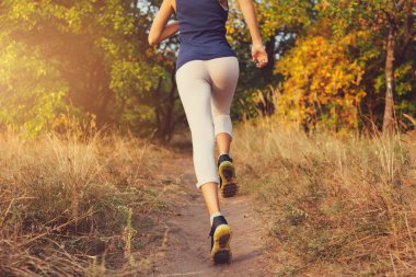 Sonbahar ormandaki kırsal bir yolda çalışan genç kadın