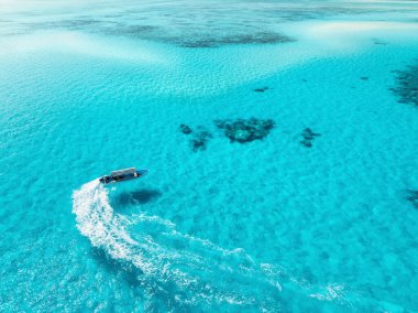 Yazın masmavi sularda yüzen teknenin havadan görüntüsü. Zanzibar adası. Yatın üst insansız hava aracı görüntüsü, dalgaların çekildiği kumsal, açık mavi deniz, beyaz kum. Tatil ve seyahat için ideal. Tropik arkaplan