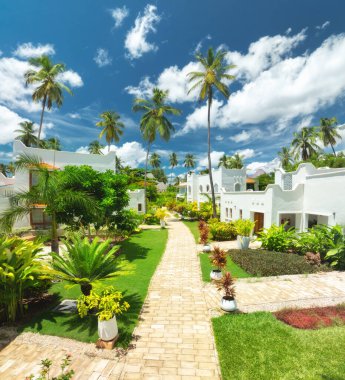 Tanzanya, Zanzibar 'da güneşli bir günde, beyaz villaları, palmiye ağaçları, taş kaldırımı ve bahçesi olan, gökyüzü. Egzotik seyahat rotası. Otelde. Afrika 'da yaz tatili