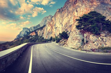 Yaz ormanında gün batımında asfalt yolda. Kırım Dağları