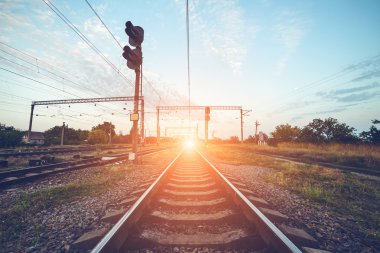 Gün batımında tren platformu ve trafik ışığı. Demiryolu. Demiryolu st