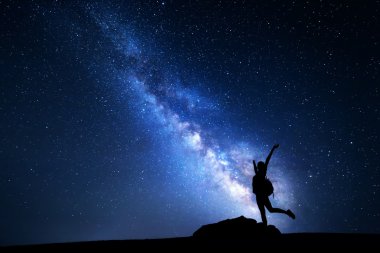 Samanyolu. Gece gökyüzünde yıldızlar ve bir kadın silueti ile