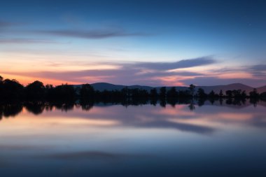 Yıldız ve suda yansıyan bulutlar dağ gölü. Gece