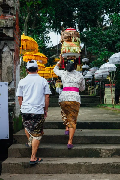 Balinese man and woman in traditional clothes going to the temple, Ubud, Bali — Stock Photo, Image