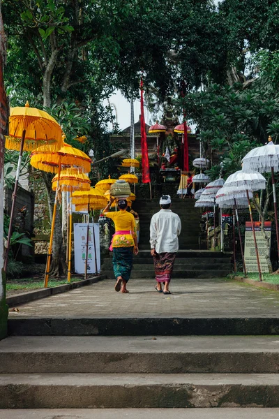 Balinese man and woman in traditional clothes going to the temple, Ubud, Bali — Stock Photo, Image
