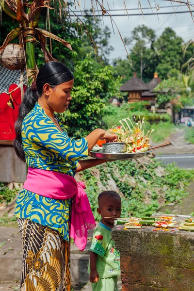 Balinesiska kvinna göra utbud i templet, Ubud, Bali — Stockfoto