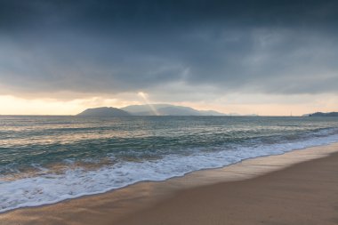 Fırtınalı gökyüzünde parlayan güneş ışını