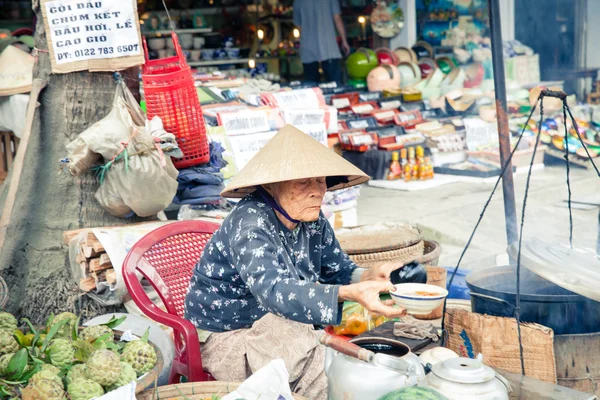 Mujeres en sombrero cónico venta de alimentos en el mercado fresco —  Fotos de Stock