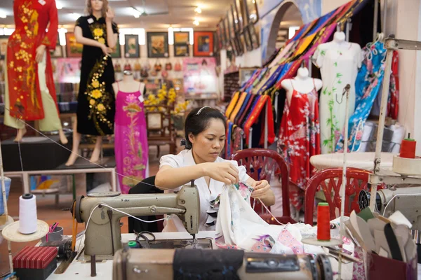 Vietnamese tailor woman sews traditional silk dress — Stock Photo, Image