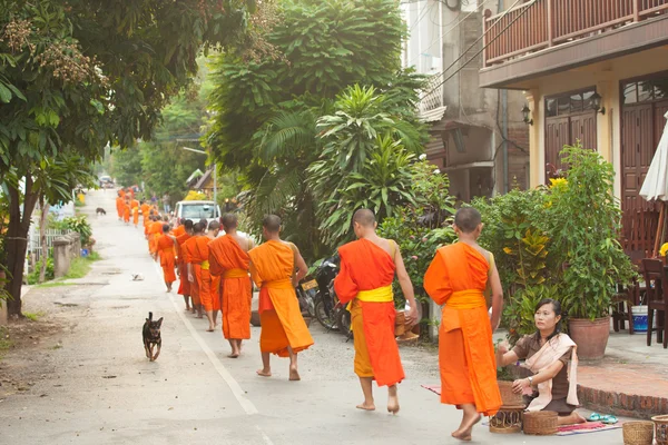 Ludzie dając jałmużnę do mnichów buddyjskich na ulicy, Laos — Zdjęcie stockowe