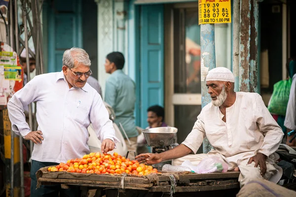 Indian człowiek kupując pomidory na ulicy Old Delhi — Zdjęcie stockowe