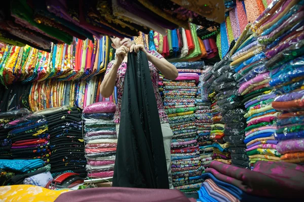 Senior Vietnamese woman selling fabric, Saigon — Stock Photo, Image