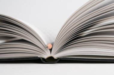 Açık kitap üzerine beyaz izole kalem ile