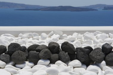 Black volcanic stones over white. Decoration detail at Santorini island clipart