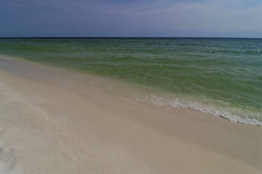 Okyanus kıyısında yakın çekim yeşil dalga, küçük dalga, sahilden gelen köpüğü oluşturur.