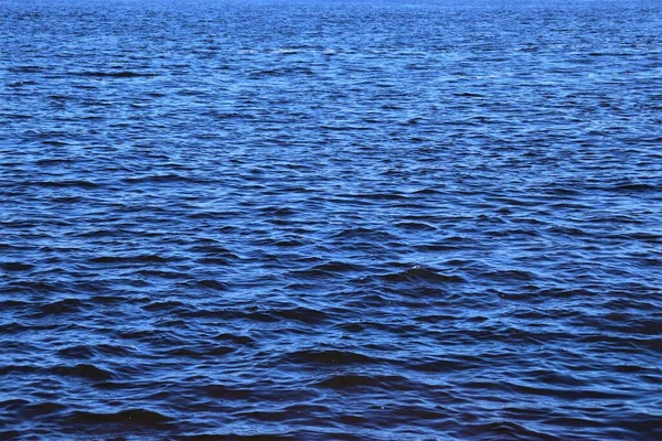 Small waves on the ocean surface, ripples on the water surface, bright blue ocean water
