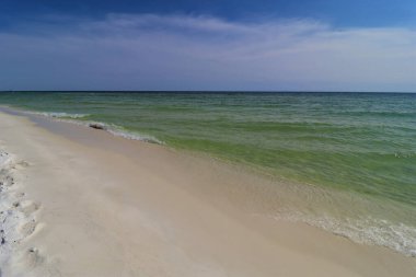 Okyanus kıyısında yakın çekim yeşil dalga, küçük dalga, sahilden gelen köpüğü oluşturur.