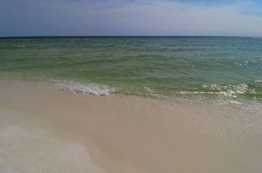 Okyanus kıyısında yakın çekim yeşil dalga, küçük dalga, sahilden gelen köpüğü oluşturur.