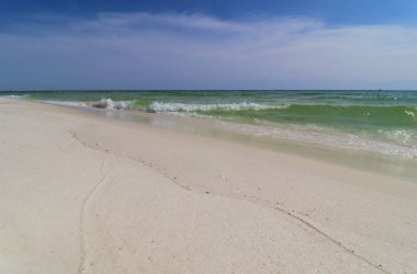 Okyanus kıyısında yakın çekim yeşil dalga, küçük dalga, sahilden gelen köpüğü oluşturur.