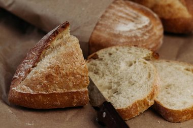 Taze ev yapımı taze ekmek, yumuşak odaklı. Fransız ekmeği. Leavenda ekmek. Mayasız ekmek. Ekmek dilimlemek için bir bıçak var..